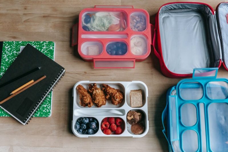 lunch boxes near notebooks on table