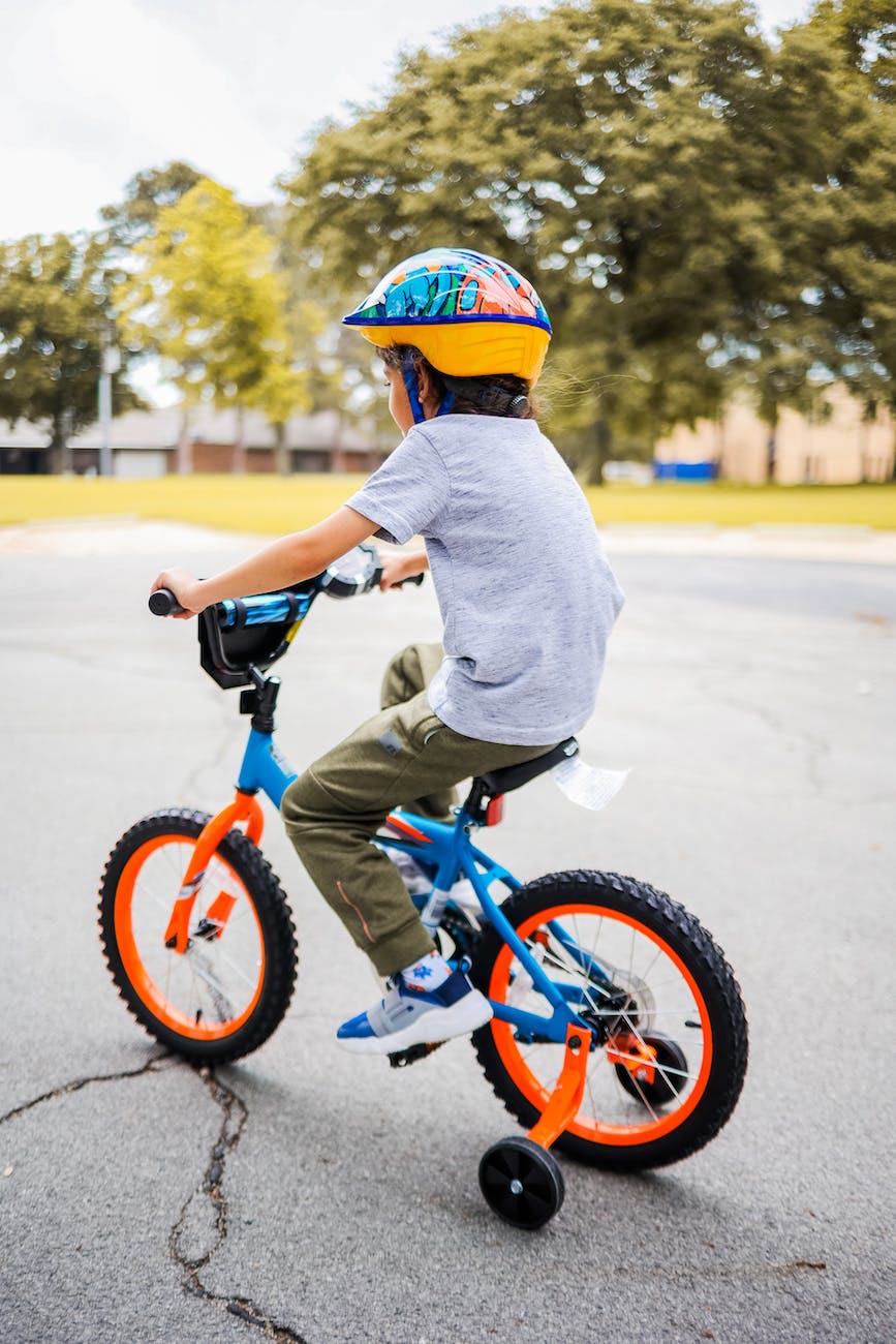 a kid riding a bicycle with a helmet